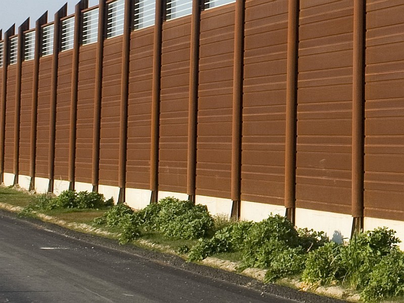 Barriera acustica realizzata con pannelli fonoassorbenti e fonoisolanti in acciaio corten e pannelli fonoisolanti in vetro stratificato antisfondamento