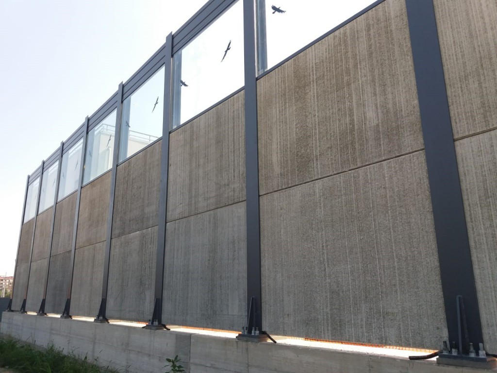Vista lato ricettore della barriera antirumore ferroviaria con pannelli fonoassorbenti e fonoisolanti